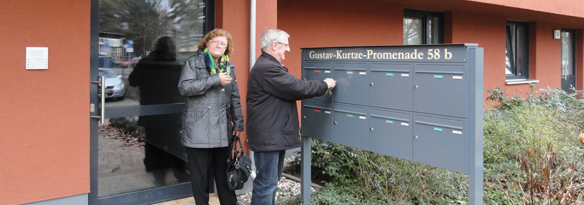 2 Mieter stehen vor dem Hauseingang der Gustav-Kurtze-Promenade, ein Haus der WBG "Aufbau" Strausberg