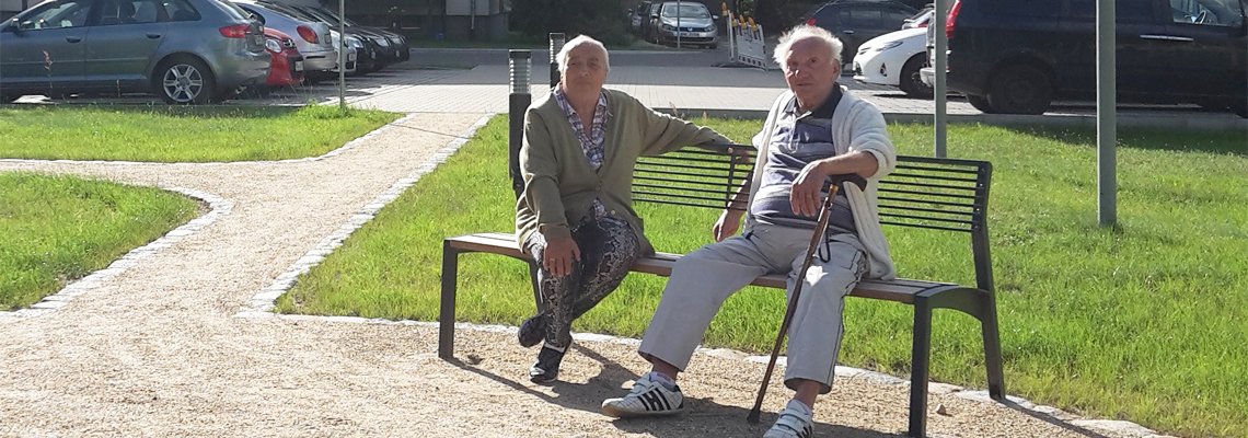 Zwei Mieter sitzen auf einer Bank im Wohngebiet der WBG 